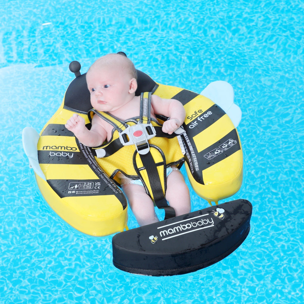 Baby floating on their back in the Bee float with the weighted tail fitted