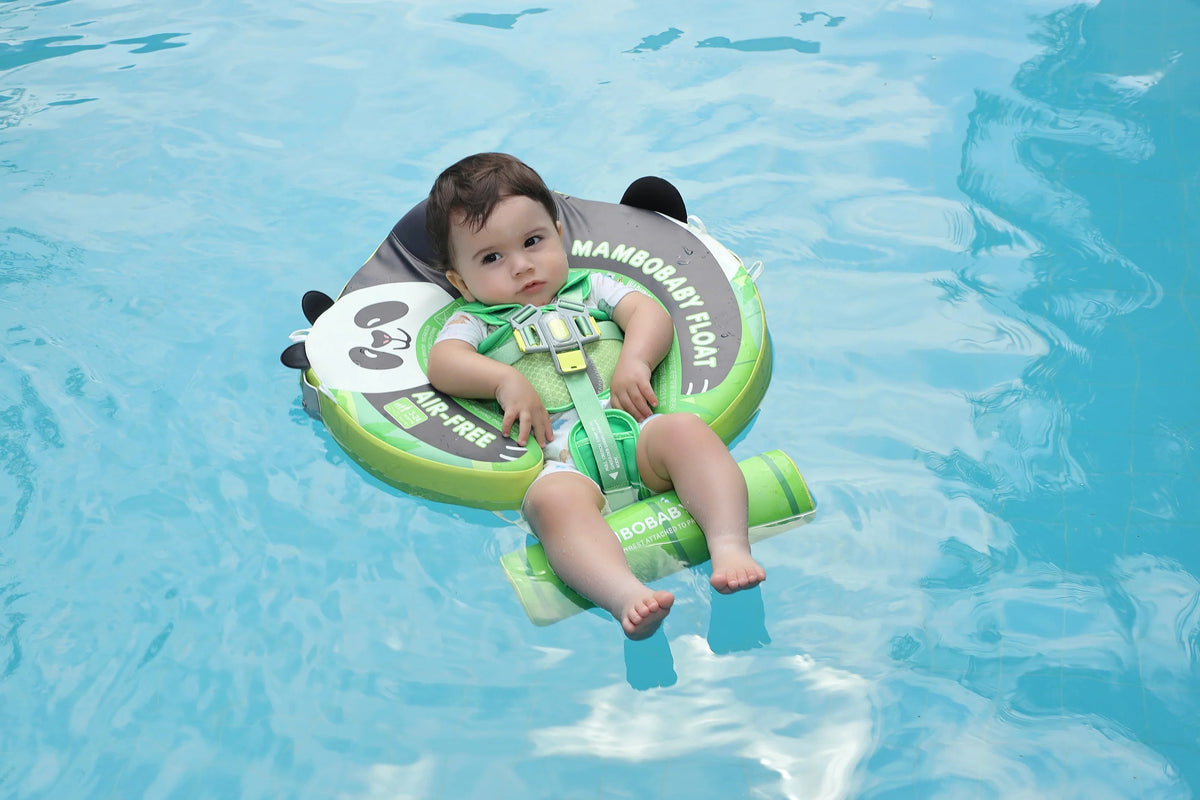Baby sitting upright in the Mambobaby Panda float in a pool, canopy shading the face